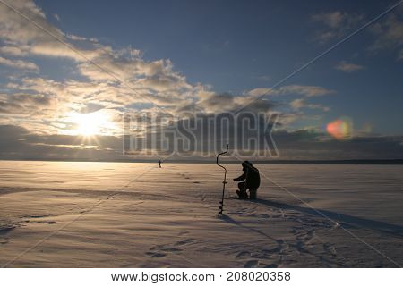 Fisherman On The River Covered With Ice