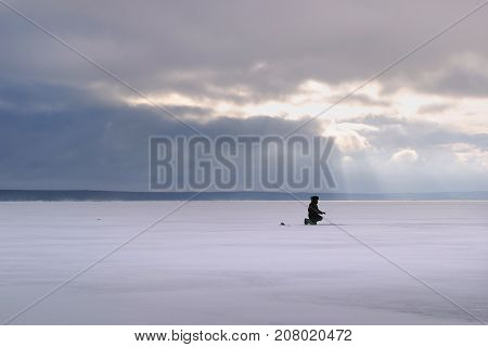Fisherman On The River Covered With Ice