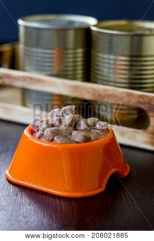 Canned pet food in a orange plastic bowl