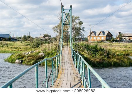 Russian rural landscape with a bridge over river