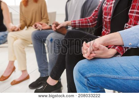 Trust circle. Company of people sitting together with united hands. Meeting of support group