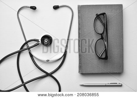 Stethoscope and book on Desk in a medical office black and white poster