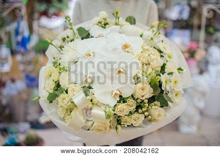 Vivid and gorgeous white bouquet of lovely flowers in woman hands. No face close up photo