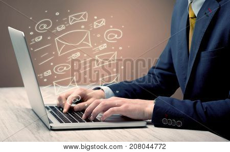 An office worker sending emails and communication with clients with the help of a portable laptop on desk concept
