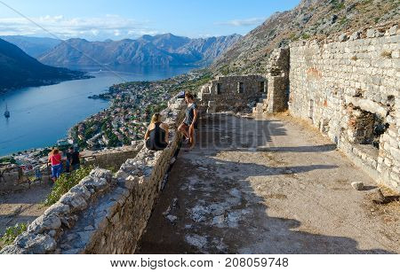 KOTOR MONTENEGRO - SEPTEMBER 8 2017: Unknown tourists visit ruins of fortress of St. John (Illyrian fort) over city of Kotor and Bay of Kotor Montenegro