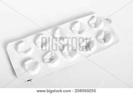 White packaged pills on a white background