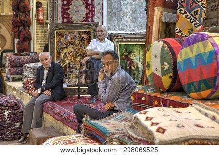 Fars Province Shiraz Iran - 19 april 2017: Three mature Iranian men are in the sales department of carpets inside the city bazaar.