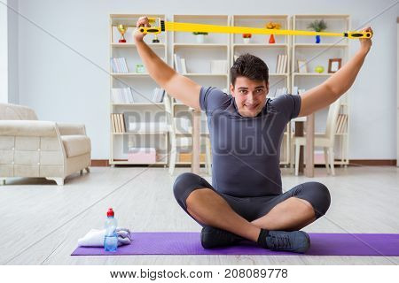 Young man exercising at home in sports and healthy lifestyle con