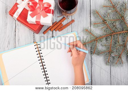 Records in a blue notepad with a blue pen in the first person