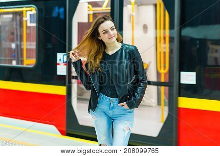 The girl near subway train at the metro station
