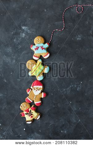 Ginger men with colored glaze on a gray background .. Gingerbread. Christmas cookies. Ginger man in a colored sweater. Gingerbread Santa