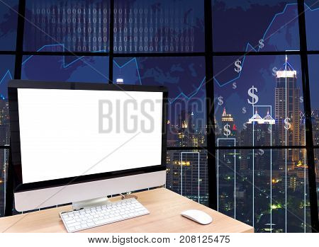 the computer on the wood table in front of the glass window over the blurred photo of cityscape background