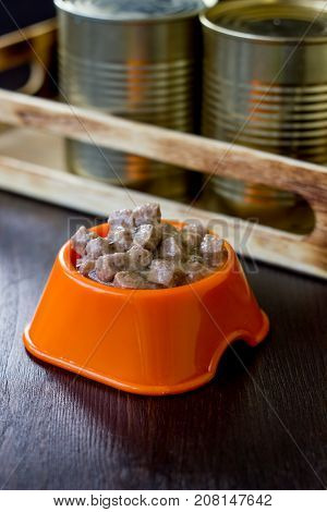 Canned pet food in a orange plastic bowl
