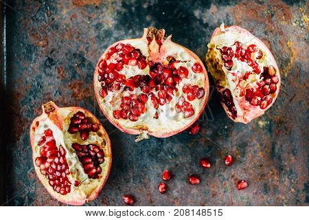 Parts of pomegranate fruit on black rustic sufrace