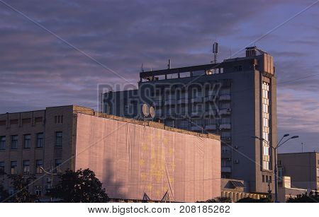 Multistory City Panel Apartment House Against The Evening Sky. Sunlight Reflection