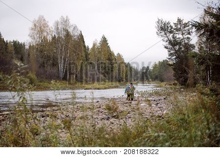 Tourists walking along the river Bank in autumn day