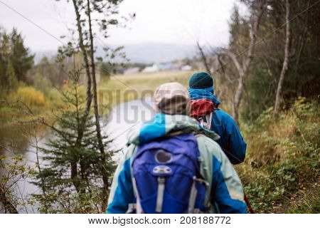 Tourists walking along the river Bank in autumn day