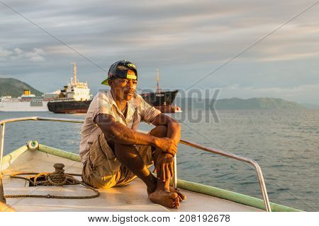 Hell-Ville, Madagascar - December 19, 2015: Malagasy boatman sailing in the rays of the setting sun on the boat in Andavakotakona Bay near Hell-Ville Nosy Be Island Madagascar.