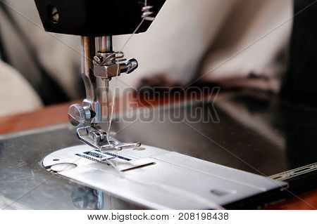Focus on the needle of sewing machine.