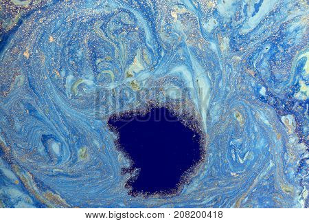 Marbled blue abstract background with golden sequins. Liquid marble ink pattern