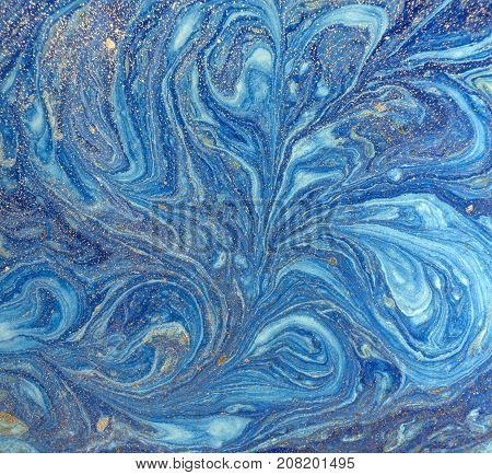 Marbled blue abstract background with golden sequins. Liquid marble ink pattern