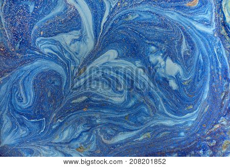 Marbled blue abstract background with golden sequins. Liquid marble ink pattern