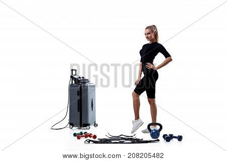 Young woman in Electrical Muscular Stimulation suit standing near EMS station isolated on white background