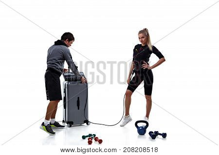 Trainer helps woman to set ems station isolated on white background
