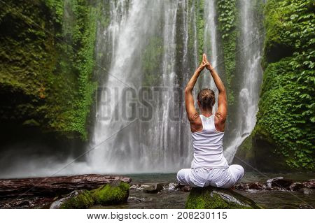 Woman Meditating Doing Yoga Between Waterfalls