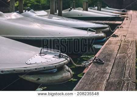 rent rowboat anchored at the pier of a lake in city park. Hamburg.