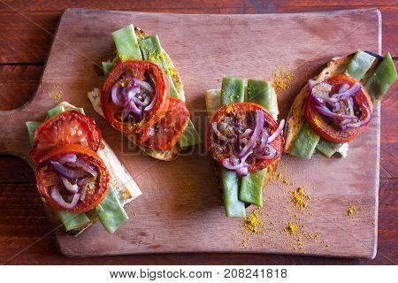 Summer sandwich prepared with fried red onion, tomato and kidney beans. Top view
