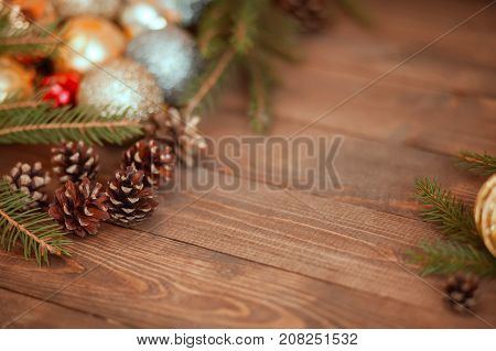 Rustic wooden pattern with pine cones spruce branches and golden christmas balls. Copyspace empty space for text.