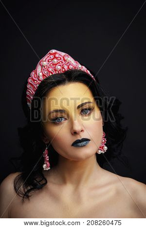 Young woman with red crown. Beauty model girl. Professional make-up.
