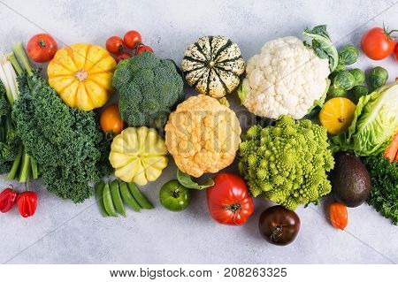Overhead table top view colorful rainbow vegetables on the light grey background, copy space for text below, selective focus