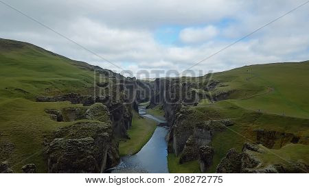 flying through the drone through the canyon Fjarrgljfur and the river going inside it on a sunny day in southern Iceland