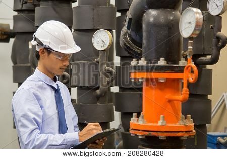 Engineer checking Condenser Water pump and pressure gauge chiller water pump with pressure gauge.