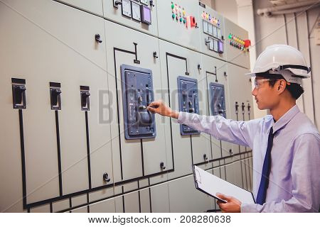Engineer is check voltage or current by voltmeter in control panel of power plant.