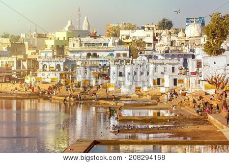 Pushkar, India - December 1, 2012: Hindu pilgrims around sacred lake in Pushkar, Rajasthan, India. With lens flare and light leak