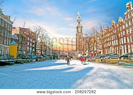 Amsterdam in winter with the Westerkerk in the Netherlands at sunset