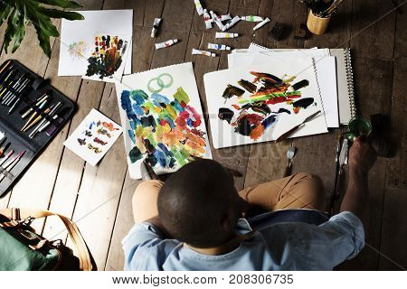 Aerial view of hand working with spatula with acrylic paint on paper