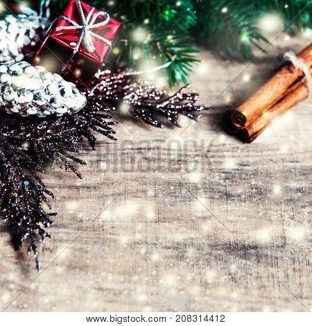Christmas gifts fir tree branches xmas holiday decorations festive symbols and falling snow on bright wooden background with copyspace