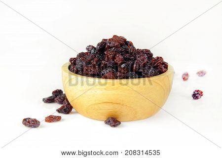 black raisins isolated on white and wooden background