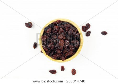 black raisins isolated on white and wooden background