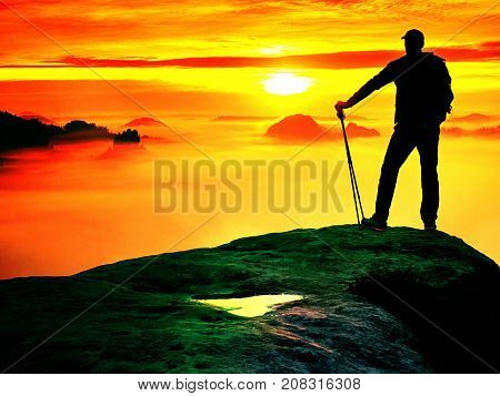 Man Silhouette With Poles In Hand. Sunny Spring Daybreak.  Hiker With Sporty Backpack Stand On Rocky