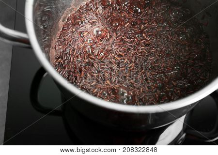 Stewpot with boiling rice in kitchen