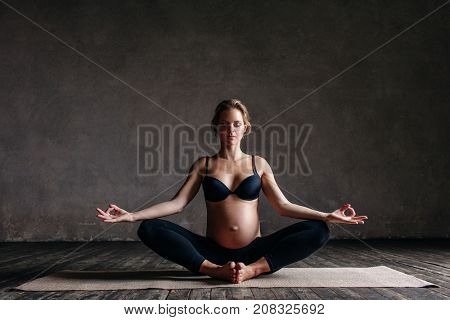 Young beautiful  pregnant yoga posing in studio