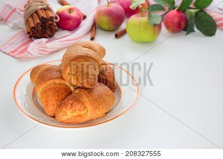 Homemade Croissant Apple In White Ceramic Plate With Fresh Apples With Leaves, Cinnamon Sticks Over