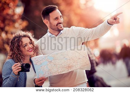Loving couple with a map looking for an address on the strreet.