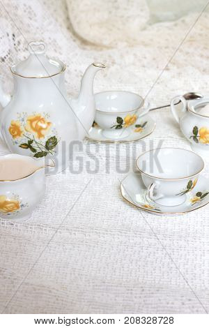 Antique tea-set with sugar and milk on white table close-up