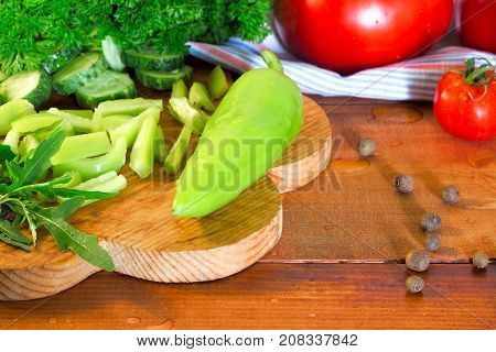 Ripe juicy farm fresh peppers tomatoes argula and parsley on rustic wooden background